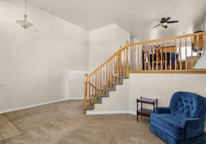 Staircase with carpet flooring and a ceiling fan