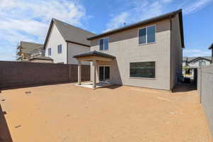 Back of house with a patio area, stucco siding, and a fenced backyard