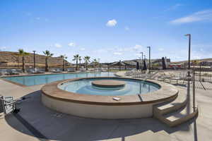 Community pool with a patio and a hot tub