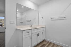 Bathroom with vanity, dark wood-style flooring, a shower, and recessed lighting