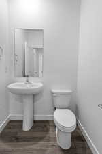Half bath with dark wood-style flooring