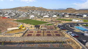 Aerial view of property and surrounding area with a mountain backdrop and nearby suburban area