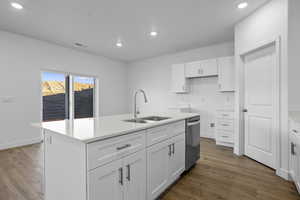 Kitchen featuring white cabinetry, an island with sink, dark wood-style floors, dishwasher, and recessed lighting