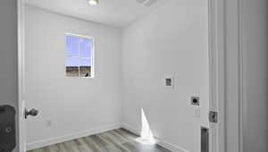 Laundry area featuring light wood-style floors, hookup for an electric dryer, and hookup for a washing machine