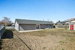 Back of house featuring a shingled roof, a patio area, a fenced backyard, and a gate