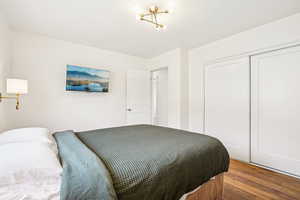 Bedroom with wood finished floors and a closet