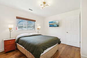 Bedroom featuring dark wood finished floors and hanging lights