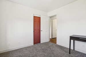 Unfurnished bedroom featuring baseboards and carpet floors