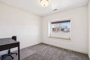 Unfurnished office featuring carpet and baseboards