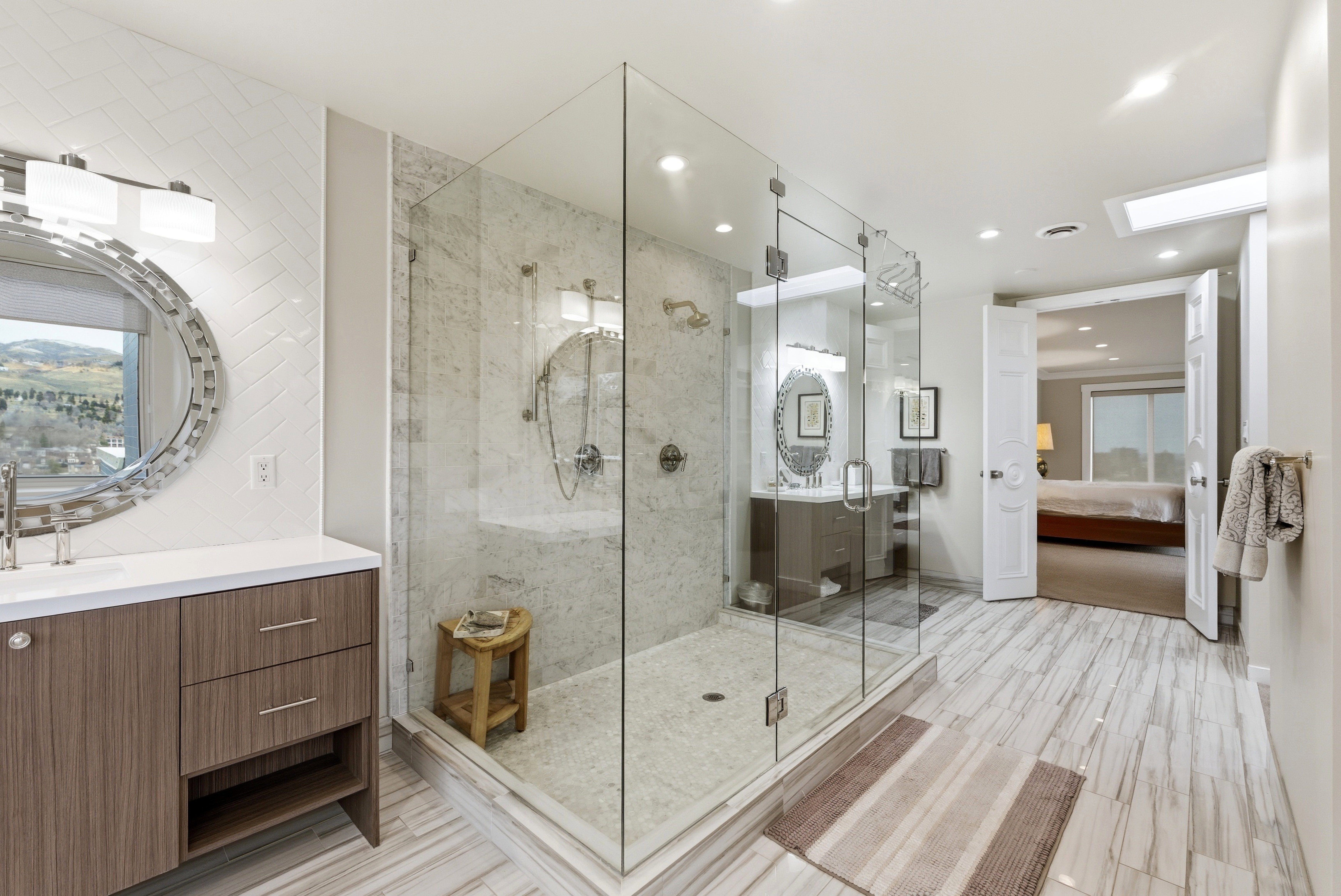 Ensuite bathroom with a marble finish shower, vanity, light wood finished floors, recessed lighting, and backsplash