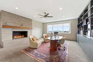 Sitting room featuring light carpet, a fireplace, ceiling fan, recessed lighting, and a desk