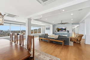 Living area with decorative columns, light wood-style flooring, and recessed lighting