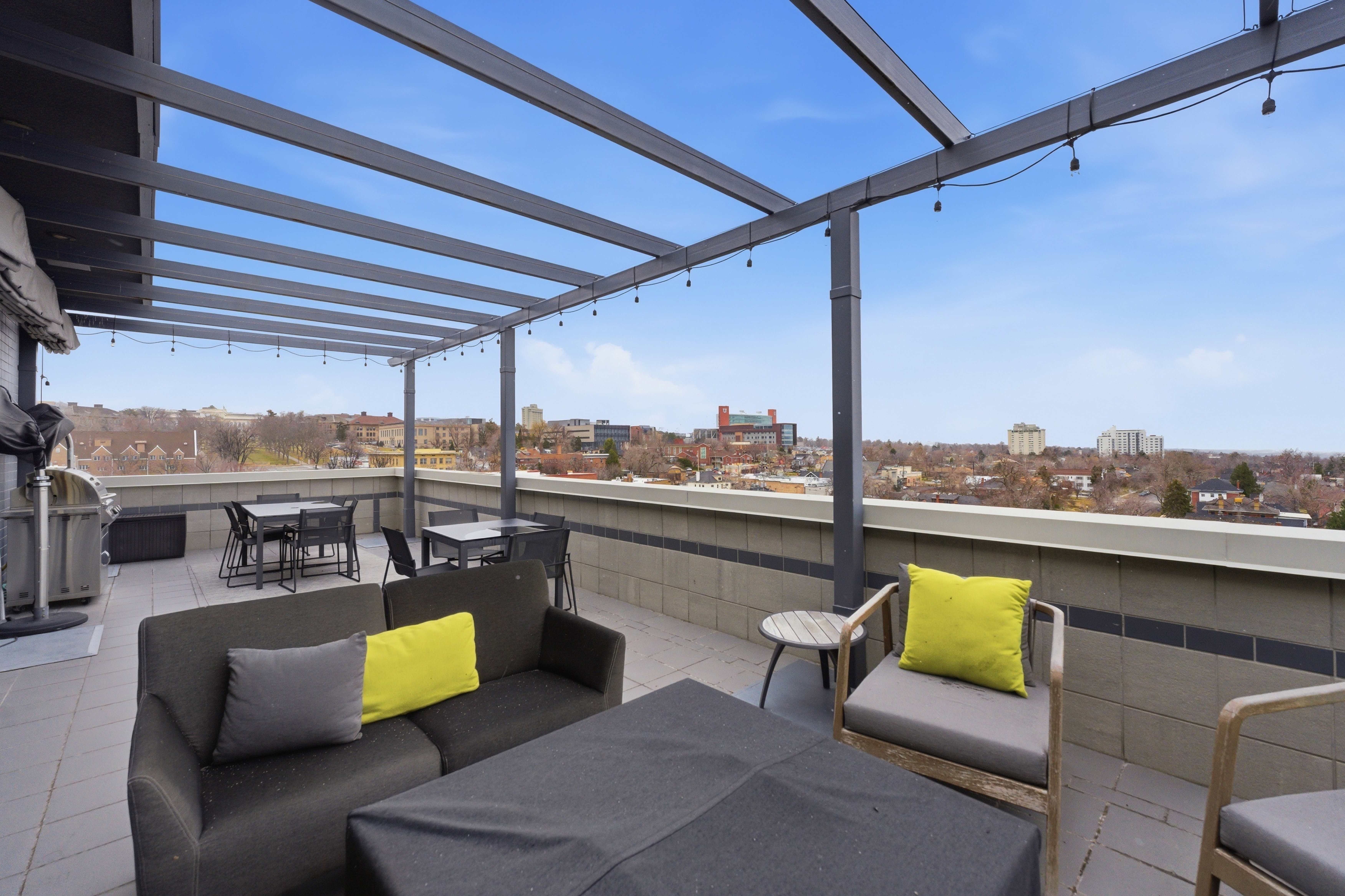 View of patio / terrace with an outdoor living / dining area, a view of city, and a grill