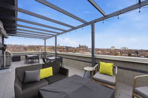 View of patio / terrace with an outdoor living / dining area, a view of city, and a grill