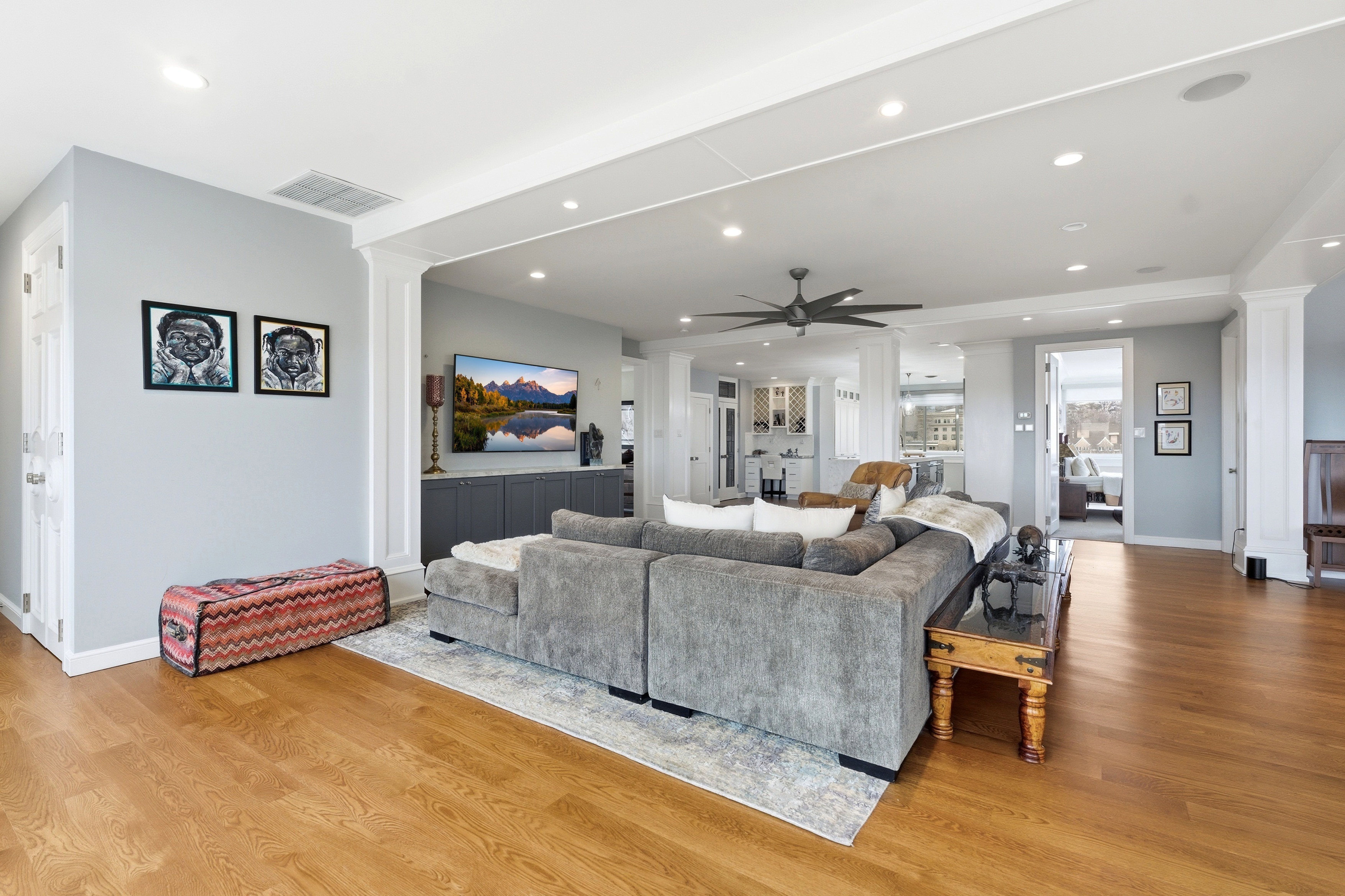 Living area featuring decorative columns, light wood-style flooring, a ceiling fan, and recessed lighting
