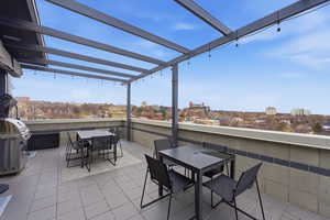 View of patio / terrace with outdoor dining area, a view of city, and a grill