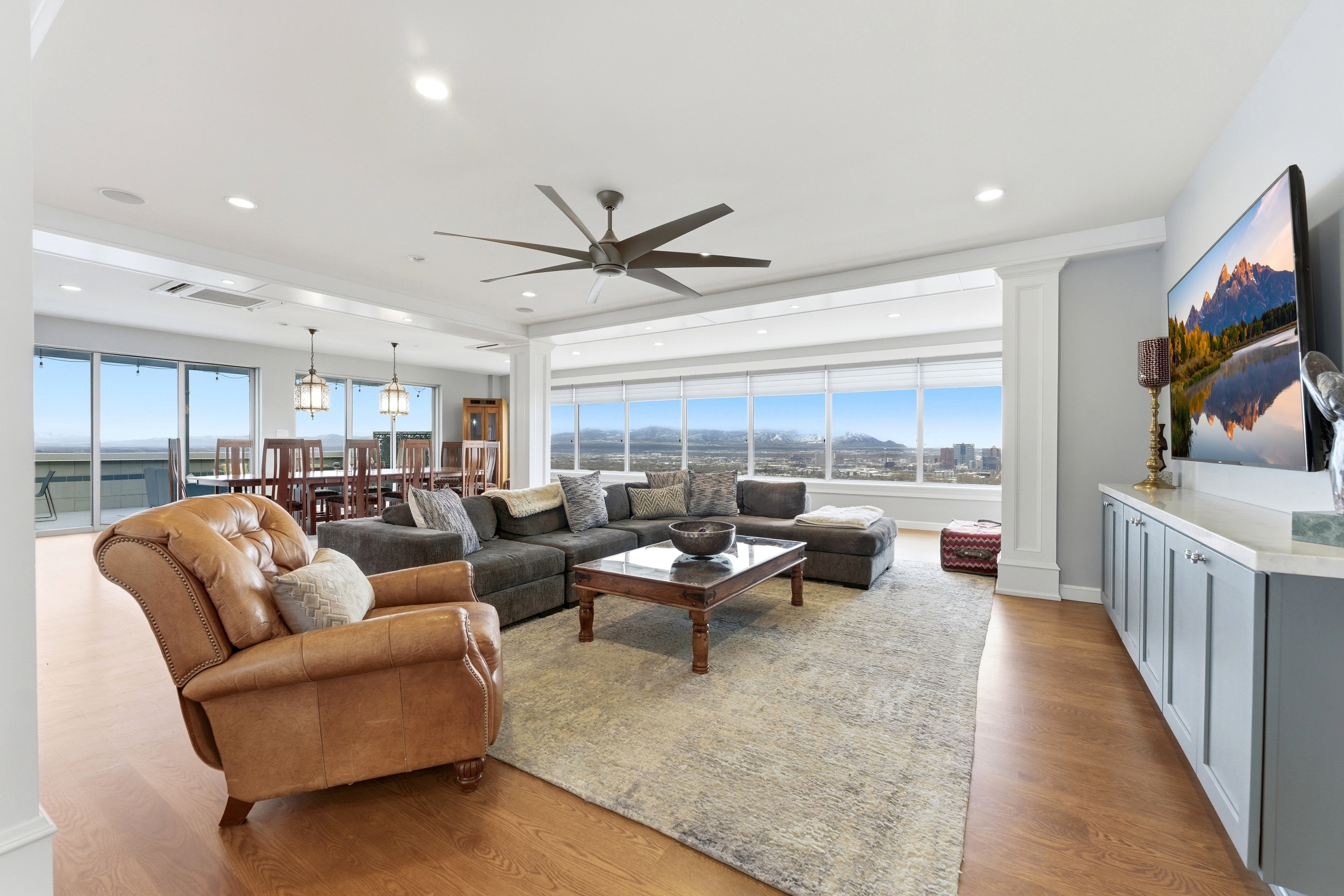 Living area featuring decorative columns, ceiling fan, wood finished floors, healthy amount of natural light, and recessed lighting