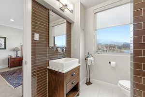 Bathroom featuring vanity, light tile patterned floors, a mountain view, ornamental molding, and recessed lighting