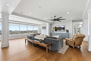 Living area featuring ornate columns, wood finished floors, recessed lighting, and ceiling fan