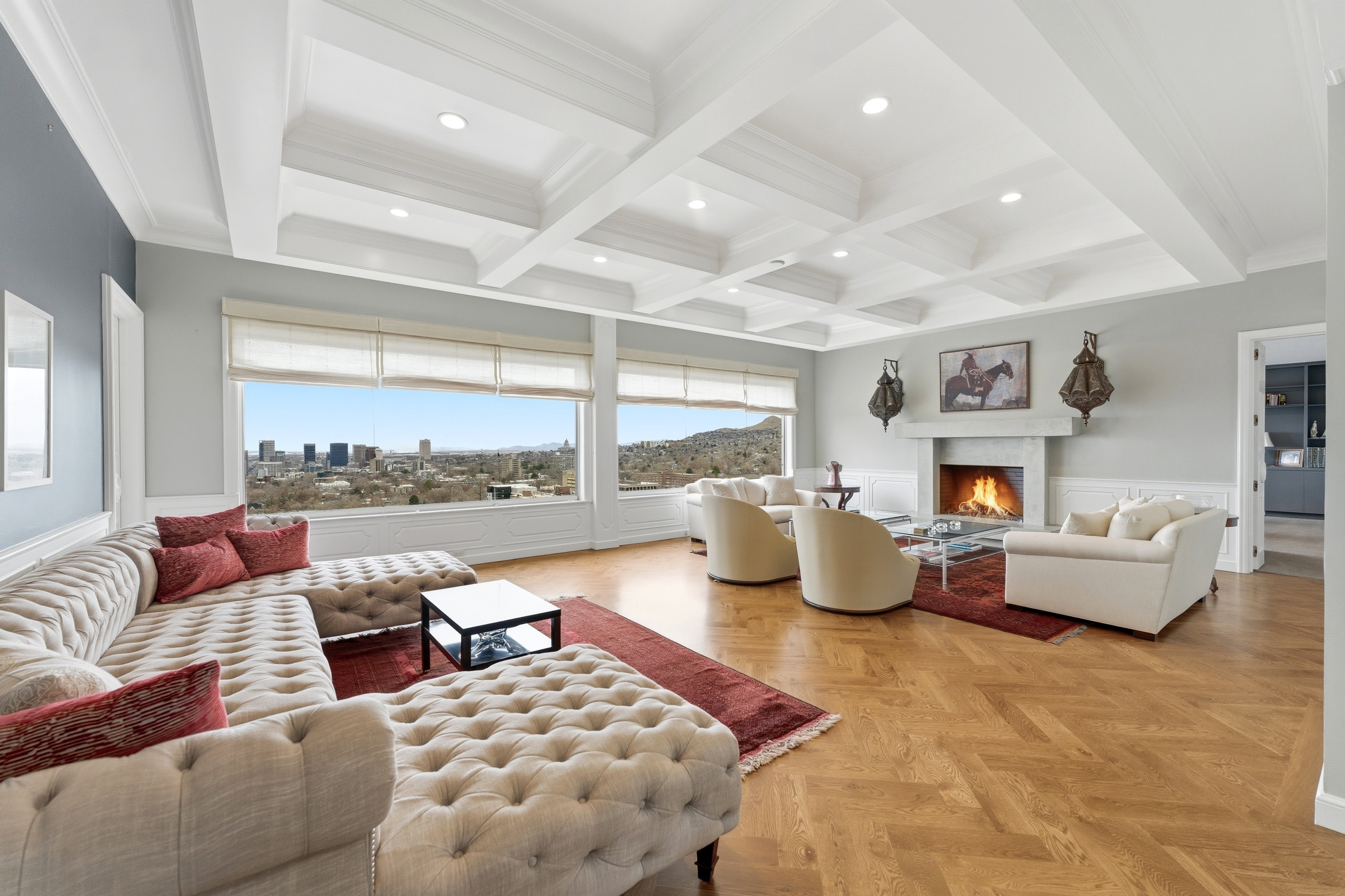 Living area featuring wainscoting, coffered ceiling, parquet flooring, a lit fireplace, and recessed lighting