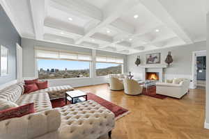 Living area featuring wainscoting, coffered ceiling, parquet flooring, a lit fireplace, and recessed lighting