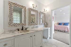 Full bathroom with connected bathroom, double vanity, light marble finish flooring, light carpet, and recessed lighting