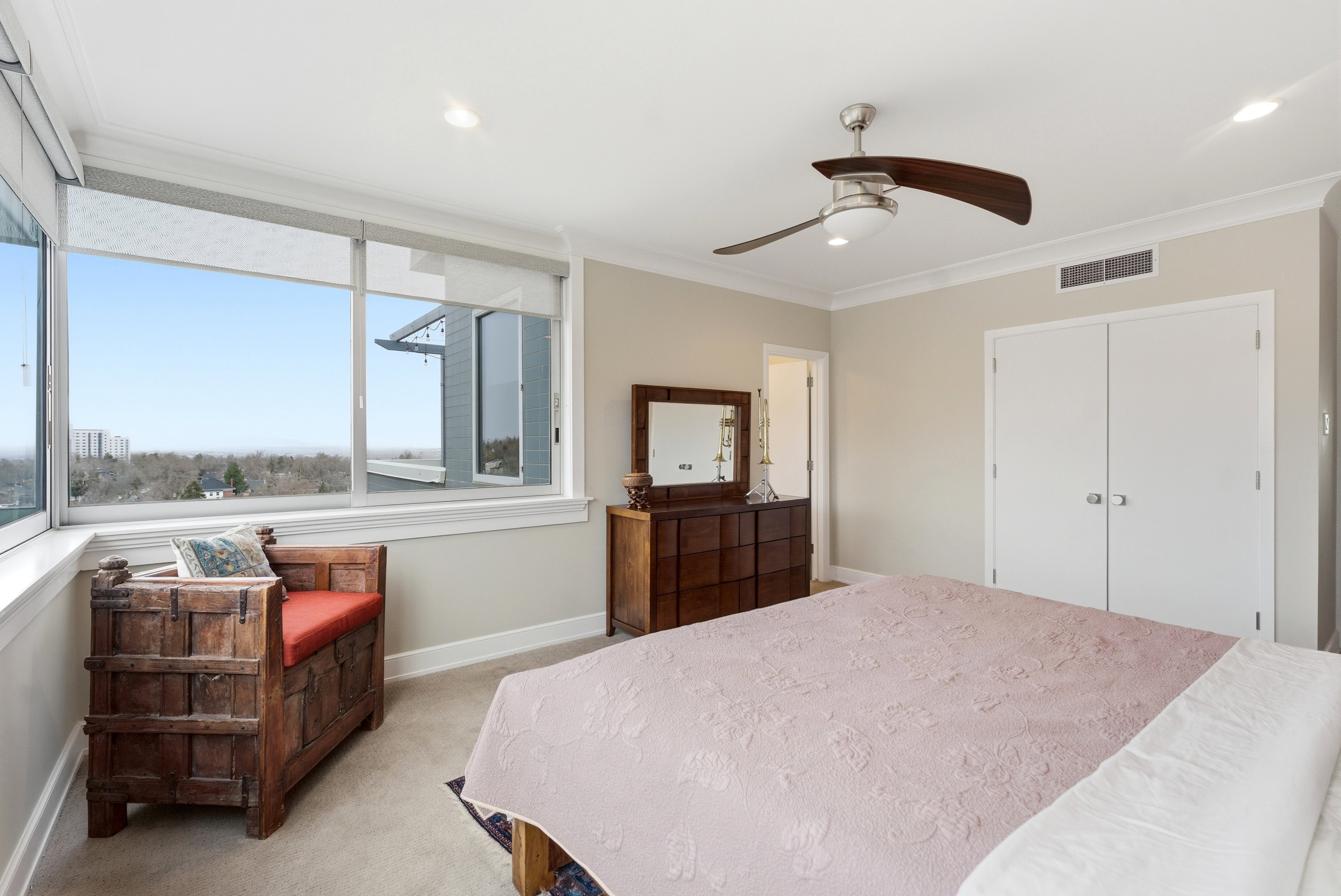 Bedroom with light colored carpet, crown molding, ceiling fan, and a closet