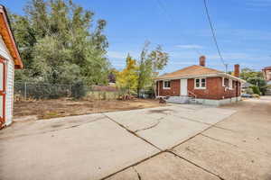 Back of property with a chimney, brick siding, and a patio area