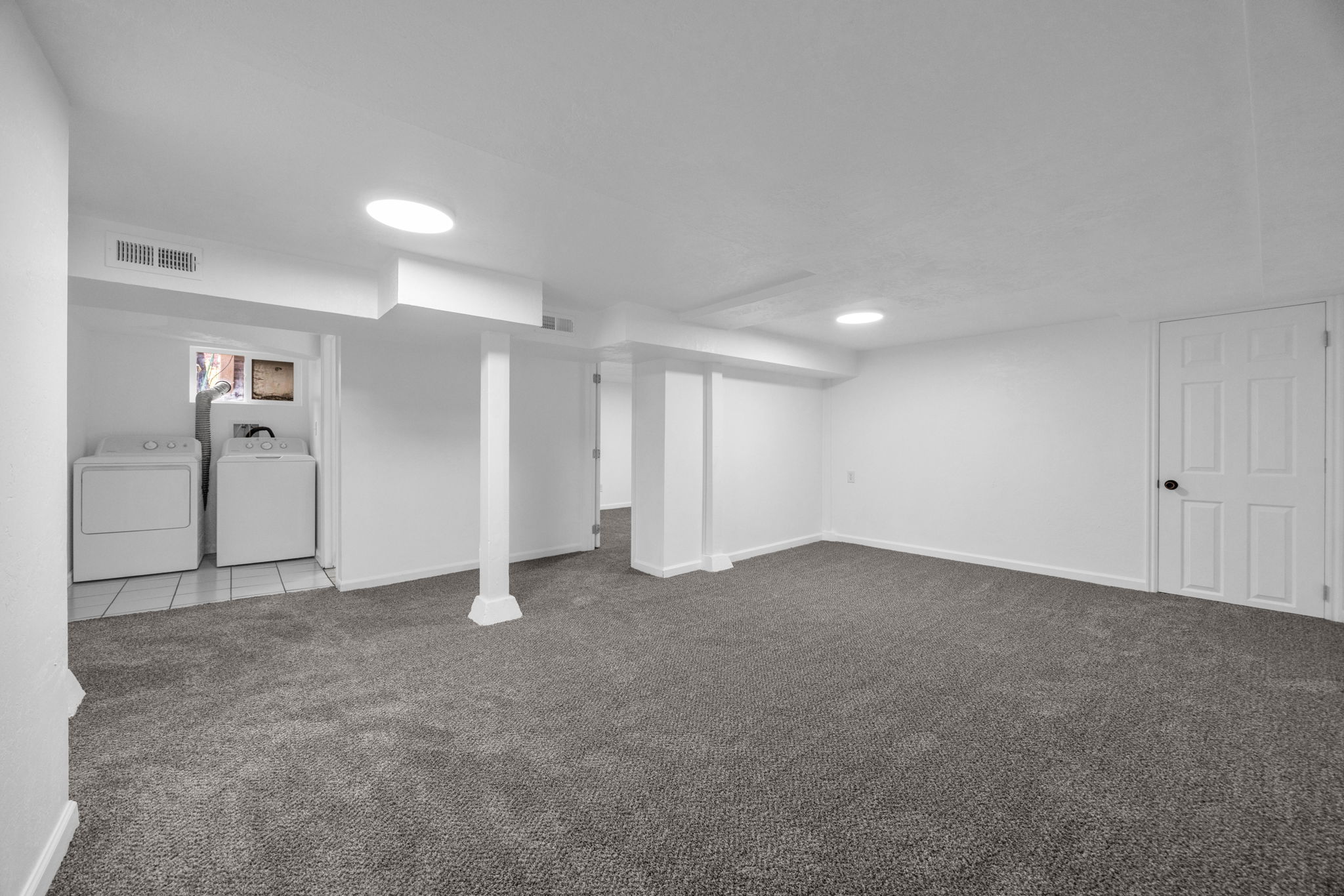 Finished basement with dark carpet and washer and dryer
