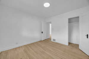 Unfurnished bedroom with light wood-style floors and a closet