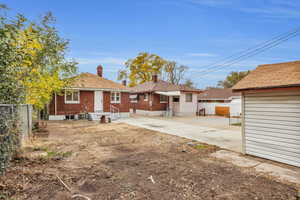 Rear view of property with brick siding and a chimney