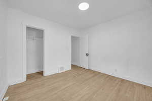 Unfurnished bedroom featuring light wood-style flooring and a closet