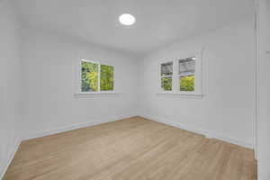 Unfurnished room with light wood finished floors and baseboards