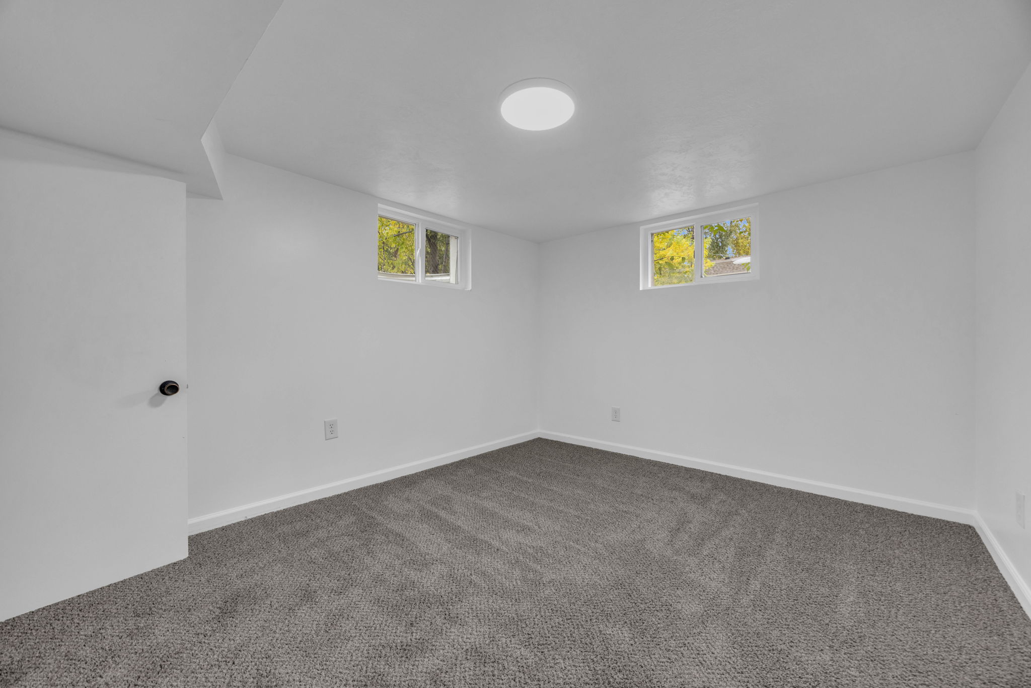 Below grade area featuring dark carpet and baseboards