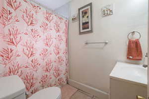 Bathroom featuring vanity, curtained shower, and light tile patterned floors