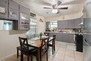 Dining area with ceiling fan and light tile patterned flooring
