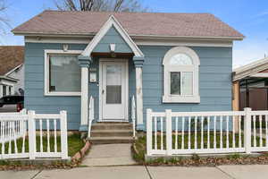 View of front of house with a fenced front yard and roof with shingles
