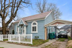 View of front of house featuring a fenced front yard, a gate, and a shingled roof
