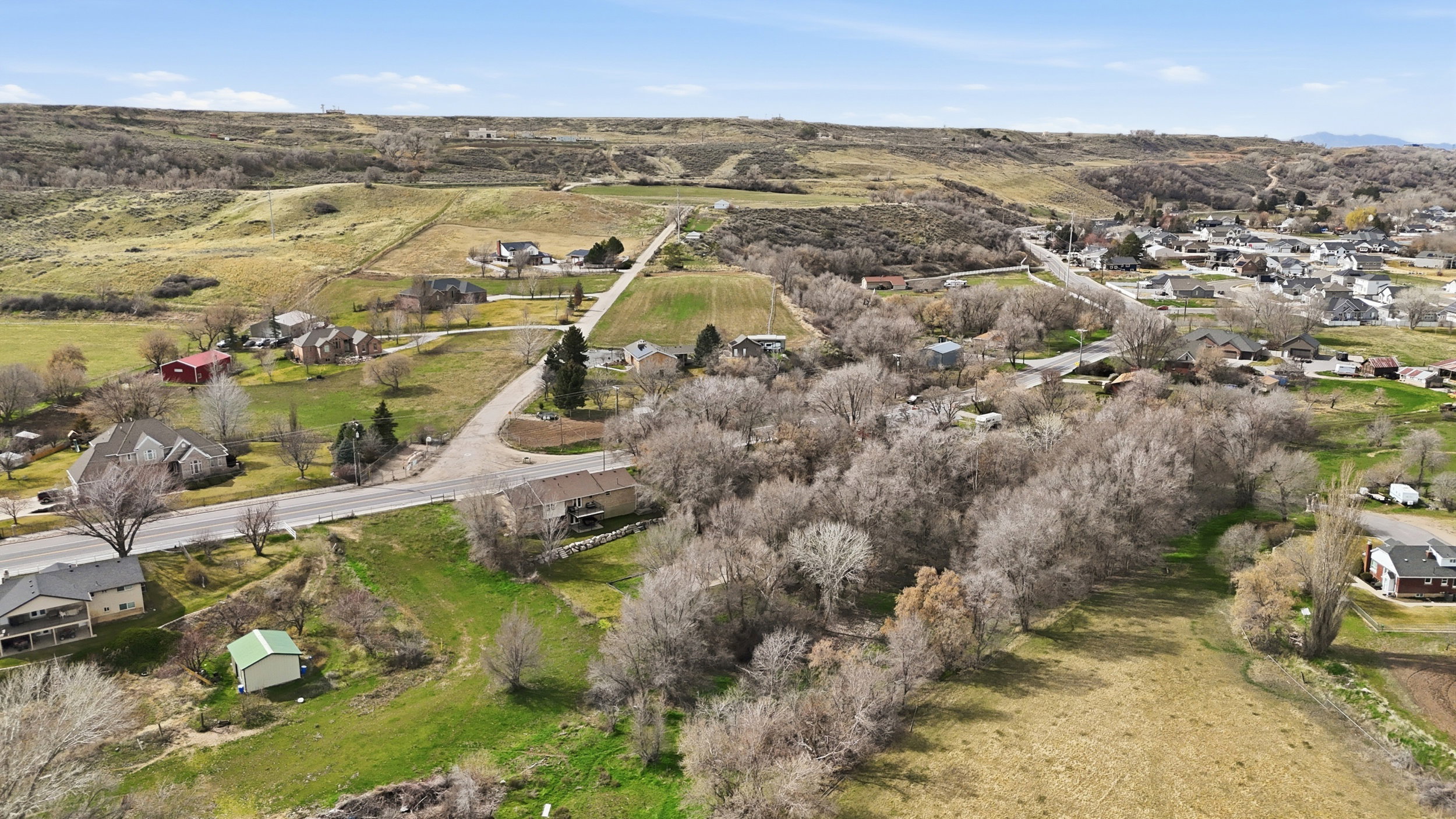 Aerial view of property and surrounding area with nearby suburban area