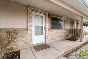 Front Porch / Entry – Covered front porch with brick accents and ample space for seating, creating a welcoming entrance and a comfortable spot to relax outdoors.