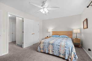 Bedroom featuring carpet, a ceiling fan, and a closet