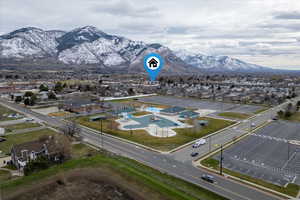 Aerial View – Neighborhood & Recreation – Aerial view highlighting the home’s location within the neighborhood with the nearby Loren Farr Pool and aquatic center, parks, and surrounding amenities, all set against the scenic mountain backdrop.