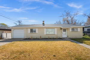 Single story home with a shingled roof, a garage, and driveway