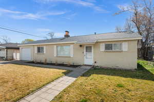 View of front of house featuring a shingled roof, a garage, a chimney, and brick siding