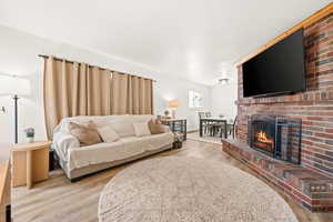 Living room featuring light wood-style floors and a fireplace