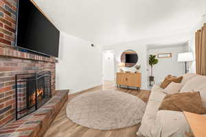Living room with light wood-type flooring and a fireplace