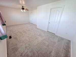 Unfurnished bedroom featuring light colored carpet and a ceiling fan