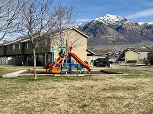 Communal playground with a residential view, a lawn, and a mountain view