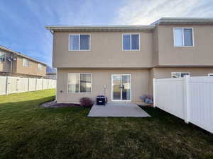 Rear view of house featuring a fenced backyard, a patio, and stucco siding