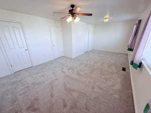 Unfurnished bedroom featuring ceiling fan and light carpet